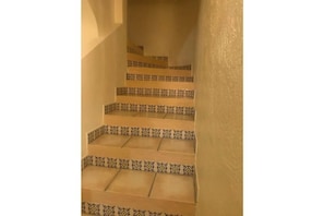 A staircase with patterned steps and beige walls.