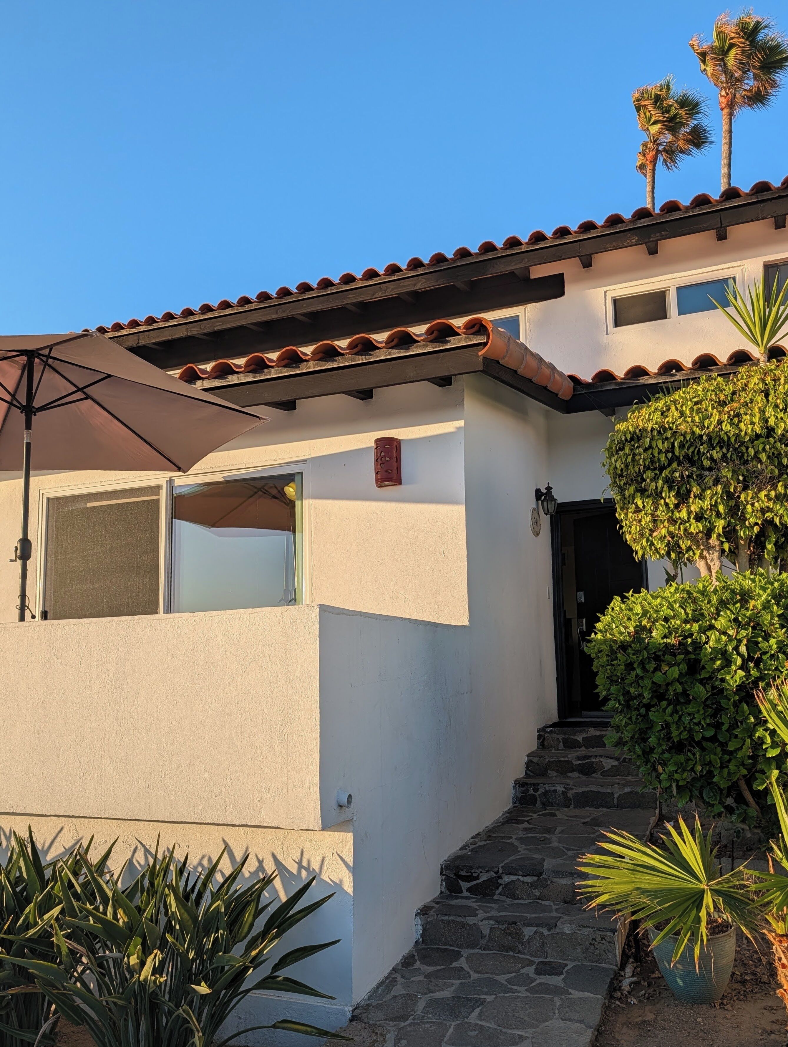 A building with a tiled roof, a door, and a small window.