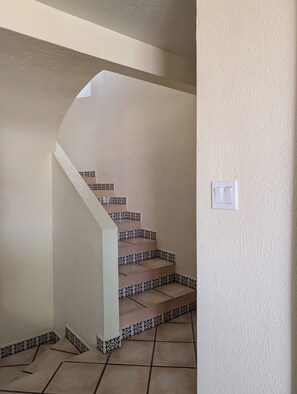 Una escalera con baldosas estampadas que lleva a una rellano.