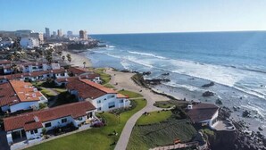 Una zona residencial costera con casas, una playa y un litoral rocoso.
