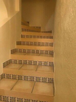 Eine Treppe mit gemusterten Stufen und beigen Wänden.