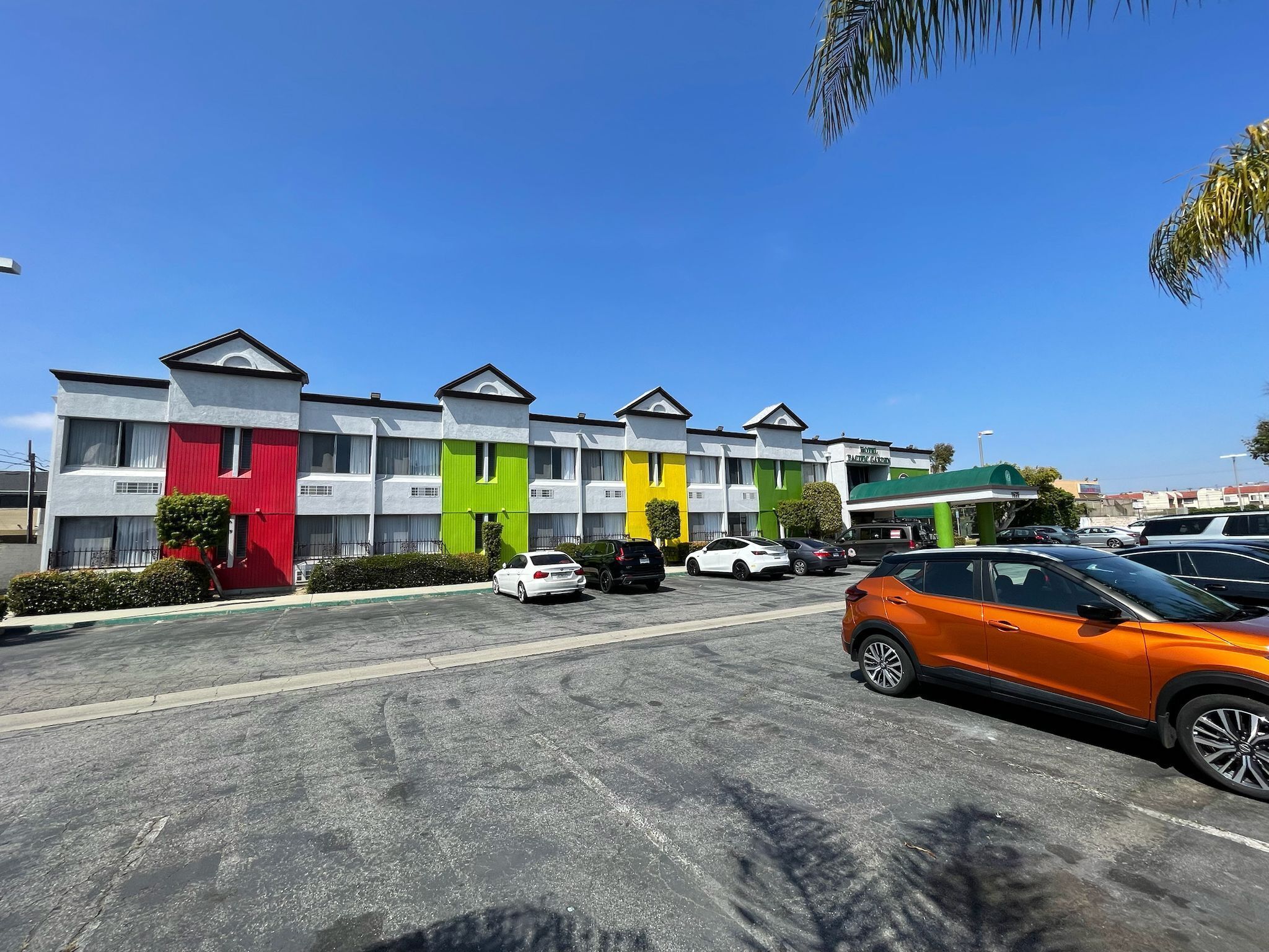 Ein mehrstöckiges Hotel mit Parkplatz.