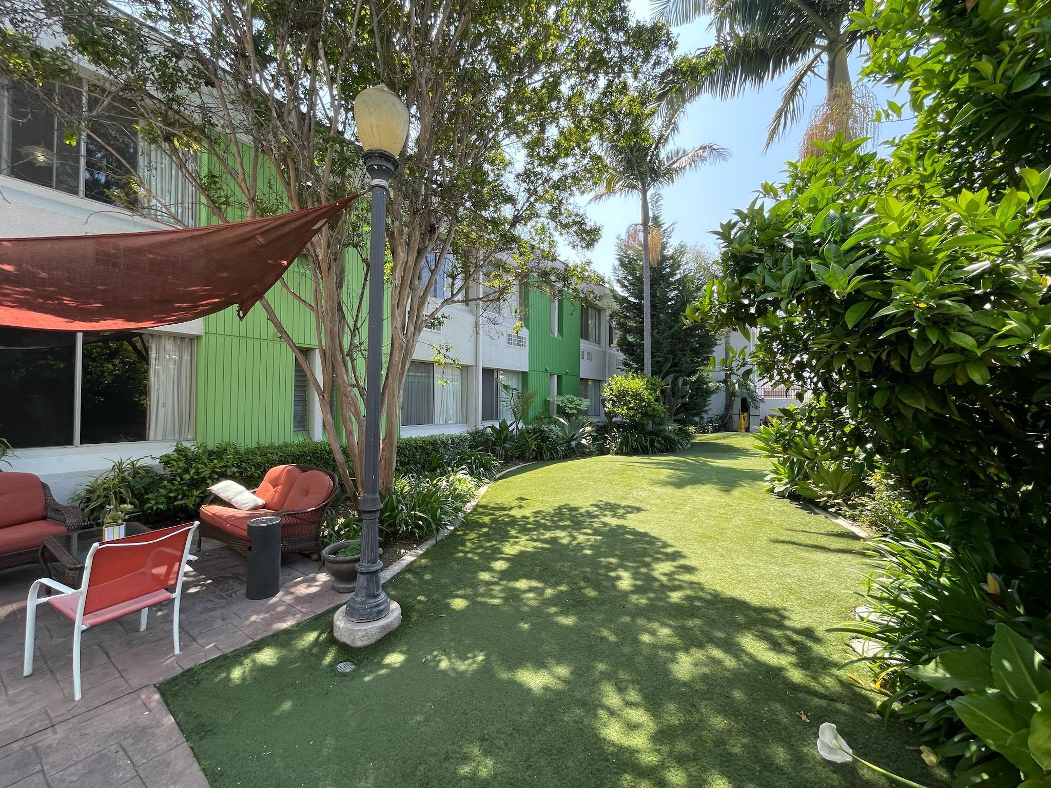 Un espace extérieur bien entretenu, comprenant une pelouse, des sièges et de la verdure.