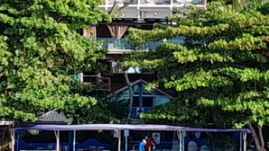 Propiedad frente a la playa con un área techada y un edificio con varias ventanas y balcones.