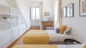 Une chambre à coucher avec un lit, une table de chevet, une lampe et une armoire.
