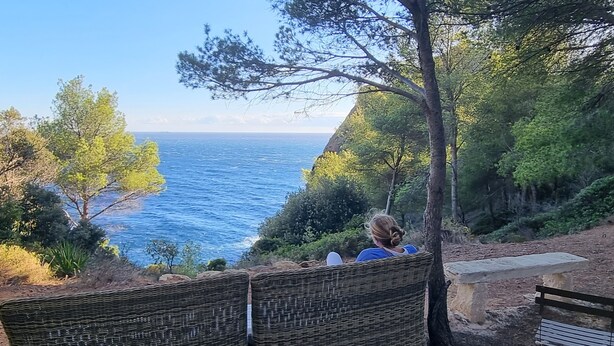 Una silla de mimbre con vistas al mar y un cielo despejado.