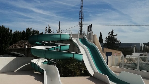 Un parque acuático con varias toboganes y un cielo despejado.