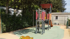 Un parque infantil con una estructura para escalar y un tobogán.