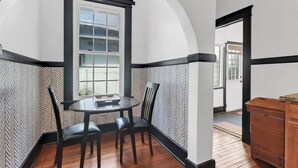 Un coin repas comprenant une table et des chaises, une fenêtre et un buffet en bois.