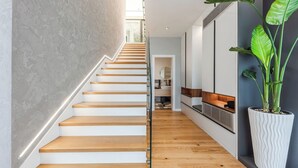 Una escalera moderna con escalones de madera y una pared de color claro.