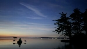 A calm lake at dusk with a person kayaking. - Quaint Cabin #3 - Pymatuning Lake (Jamestown)