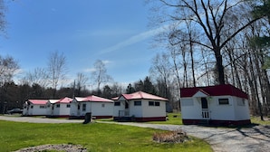 A row of mobile homes with red roofs, surrounded by trees and a clear sky. - Quaint Cabin #3 - Pymatuning Lake (Jamestown)