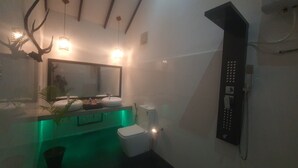 A bathroom with a mirror, two sinks, a toilet, and a shower.