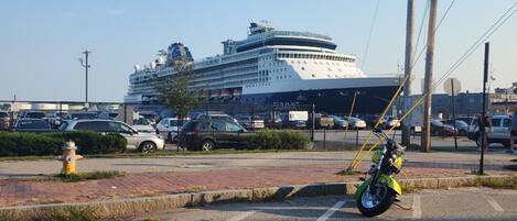 Un gran crucero atracado en un puerto, con una calle pavimentada al frente.