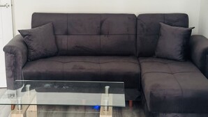 A dark brown sectional sofa with wooden legs and a glass coffee table in front. - Great family home to relax.
Within easy reach to London, Gatwick & Wimbledon . (Croydon)