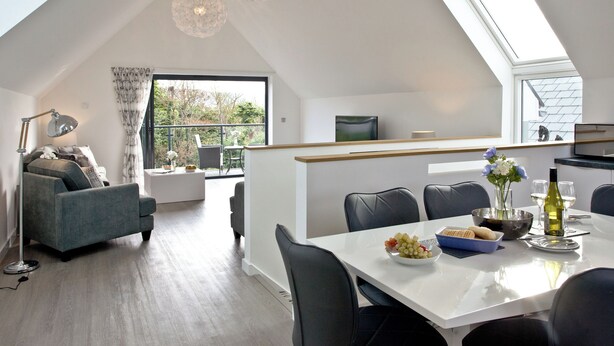 A modern loft with a dining area, a sofa, a TV, and a large window. - 3 bedroom accommodation in Westward Ho! (Westward Ho!)