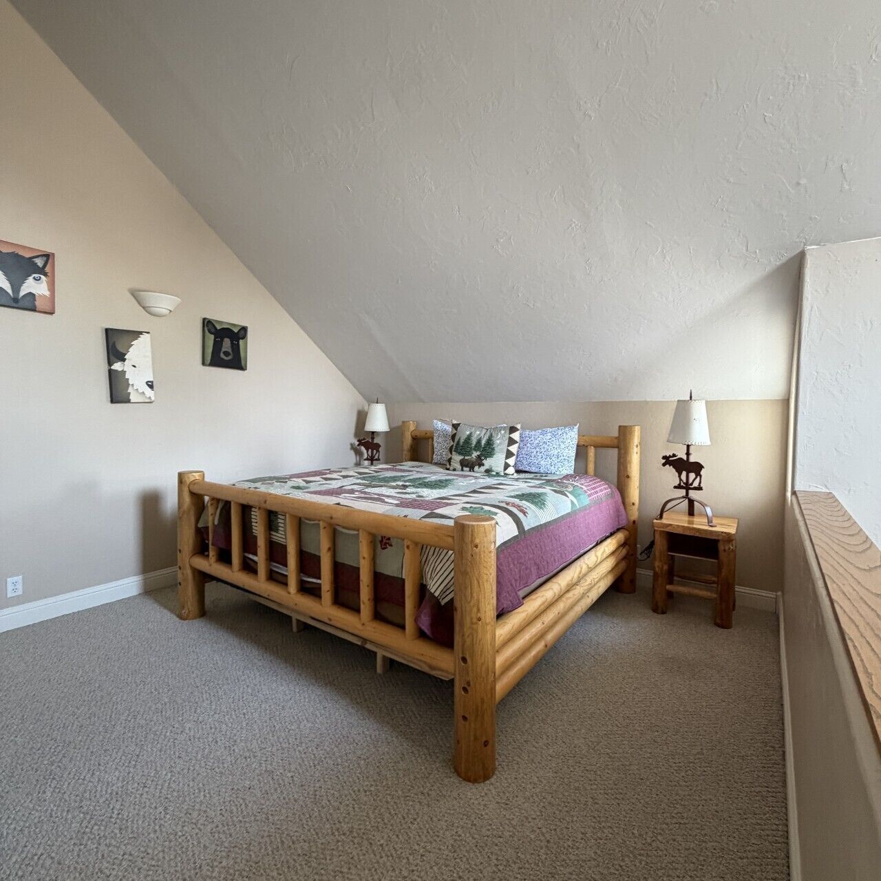 Un dormitorio con cama de madera, una mesita de noche, lámpara y decoración en la pared.