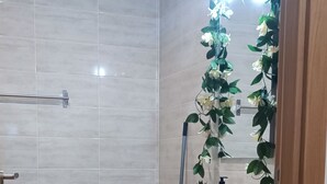 A bathroom with a white sink, a mirror, and a shower area. - Mondalva Apartamentos (Penacova)