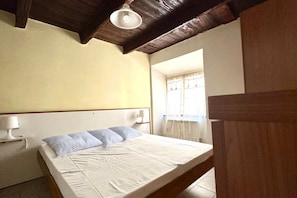 A bedroom with a bed, a nightstand, a lamp, and a window with curtains. - SE080 - Senigallia, comfortable four-room apartment in the historic center (Senigallia)