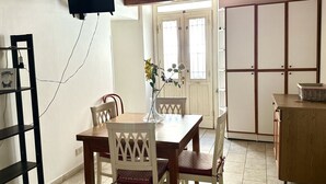 A dining area with a table, chairs, a vase with flowers, a television mounted on the wall, and a wardrobe. - SE080 - Senigallia, comfortable four-room apartment in the historic center (Senigallia)