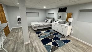 A bedroom with a bed, dresser, and a TV mounted on the wall. - Peaceful one bedroom in university district (Buffalo)