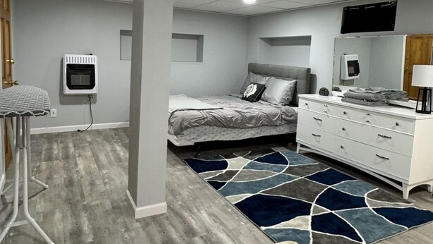 A bedroom with a bed, dresser, and a television. - Peaceful one bedroom in university district (Buffalo)