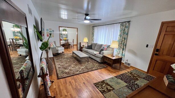 A living room with a sofa, coffee table, and a dining area in the background. - Enjoy this spacious ranch-style house next to the quilting capital of the world. (Hamilton)