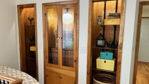 A hallway with wooden doors leading to closets, each containing baskets and storage boxes. - Enjoy this spacious ranch-style house next to the quilting capital of the world. (Hamilton)
