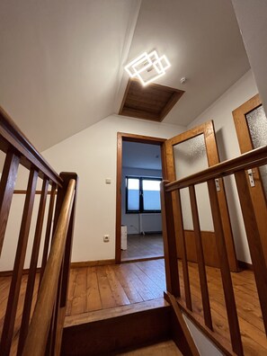 A wooden staircase with a modern light fixture, leading to a room with a view through a window. - Zentral Gelegene Ferienwohnung Am Langenberg, Hitzacker (Hitzacker (Elbe))