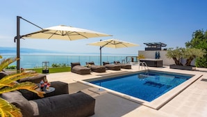 A rooftop pool area with lounge chairs, umbrellas, and a hot tub. - Stunning home in Opatija with sauna (Opatija)