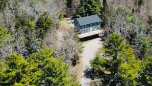 A house surrounded by dense forest, with a visible driveway leading to the entrance. - Acadia Retreat:18 Miles to Acadia NP!Secluded, Pet Friendly, Spacious. (Ellsworth)