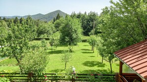 Un paisaje exuberante y verde con una cabaña de madera y un jardín cercado.