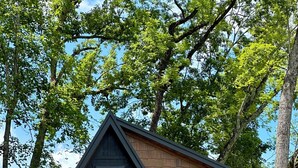 A cabin with a dark exterior, a wooden deck, a welcome sign, and a number 489. - New Modern A-Frame Near Mammoth Cave National Park with Nolin Lake Views! (Cub Run)