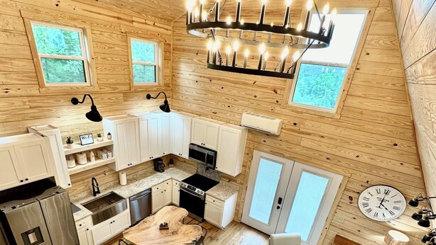 A spacious cabin with a kitchen, dining area, and seating space. - New Modern A-Frame Near Mammoth Cave National Park with Nolin Lake Views! (Cub Run)