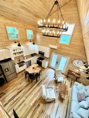 A spacious cabin with a kitchen, dining area, and seating space. - New Modern A-Frame Near Mammoth Cave National Park with Nolin Lake Views! (Cub Run)