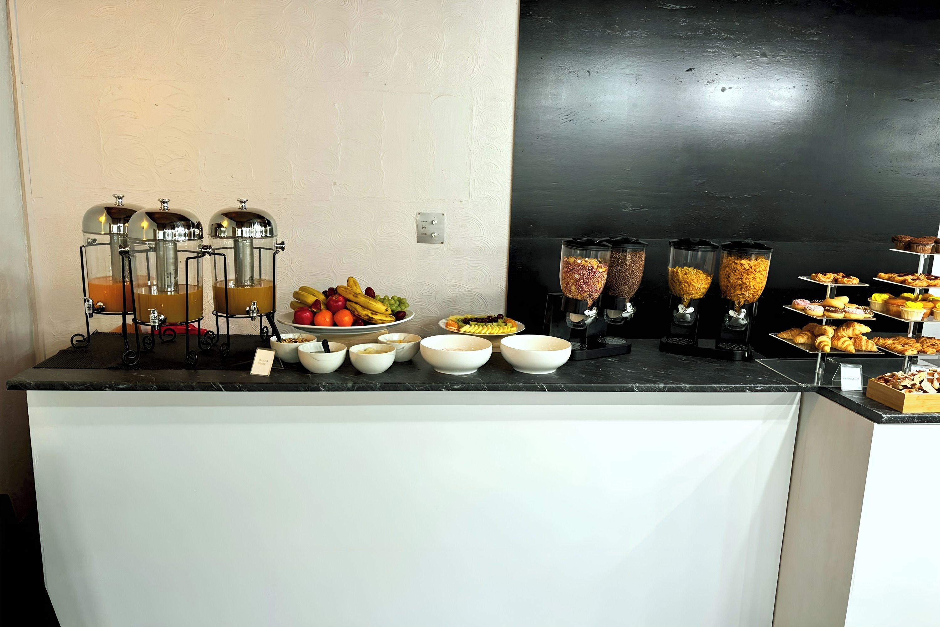 A buffet setup with various food items and drink dispensers.