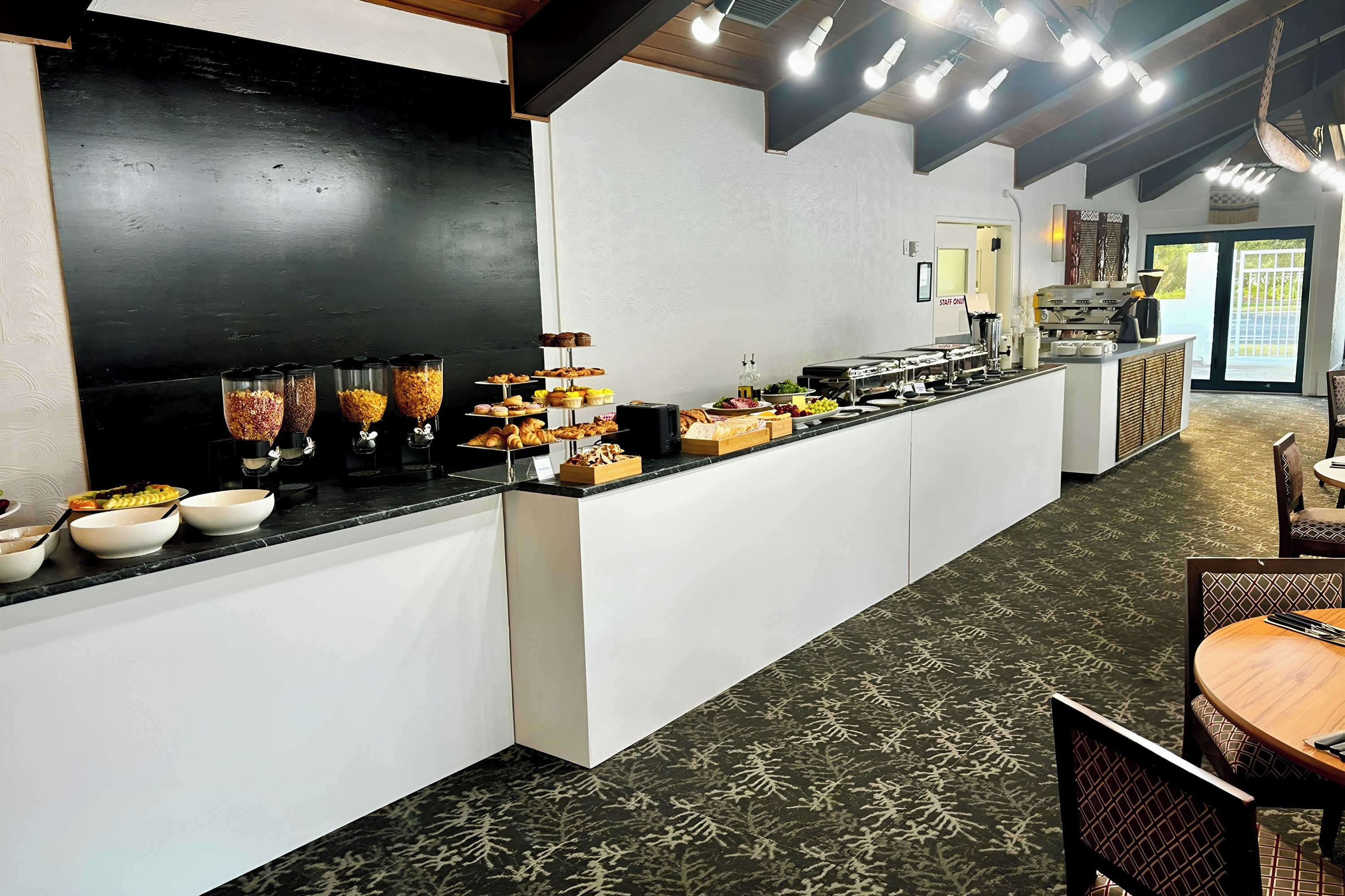 A buffet area with various food items and a coffee station.