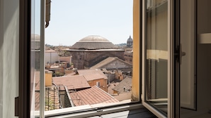 A view from a window overlooking a cityscape with historical buildings and a dome structure. - Penthouse with Terrace, Pantheon and 360° City views!! Walk to all attractions (Roma)
