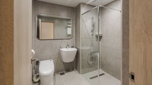 A modern bathroom with a glass-enclosed shower, a sink, and a toilet. - QVIST HOTEL (Dangjin)