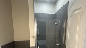 Un baño con ducha, inodoro y lavamanos.