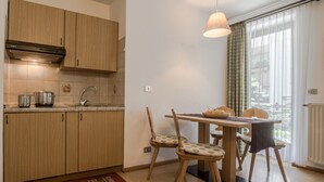 Eine Küche mit Holzausstattung, einer Spüle und einem Essbereich mit zwei Stühlen und einem Tisch.