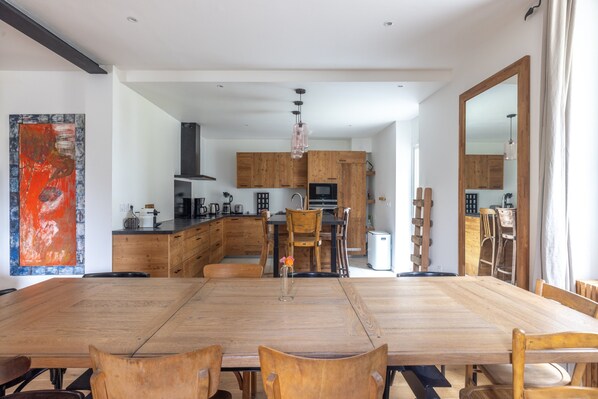 Une cuisine moderne avec des meubles en bois, une table à manger et des chaises.