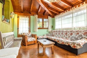A cozy room with a wooden ceiling, a sofa, a bench, and a small table.