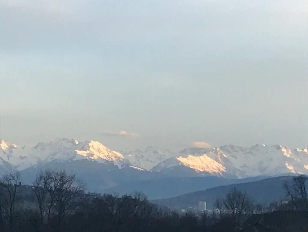 Une chaîne de montagnes aux sommets enneigés, sous un ciel dégagé.