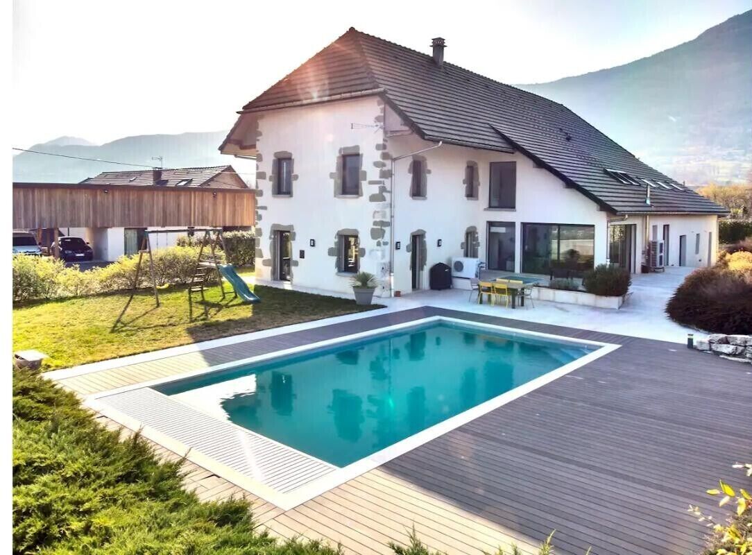 Ein Haus mit Schwimmbad, Terrasse und Blick auf die Berge.