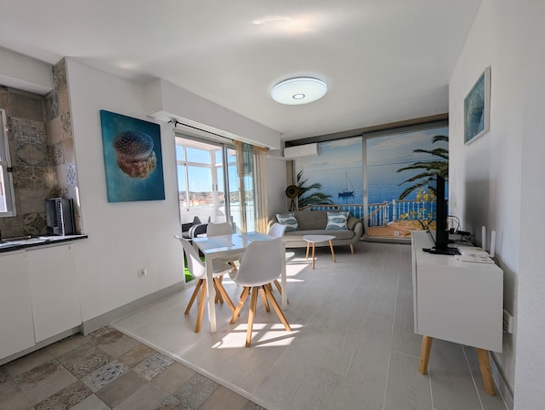 Una cocina moderna con comedor, un sofá y vistas al mar.