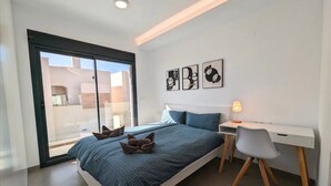 Une chambre moderne avec un lit, un bureau et une grande fenêtre.