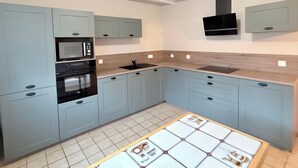 Una cocina moderna con armarios azul claro, microondas integrado, horno y lavaplatos.