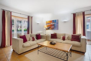 A living room with two sofas, a coffee table, and a painting on the wall.