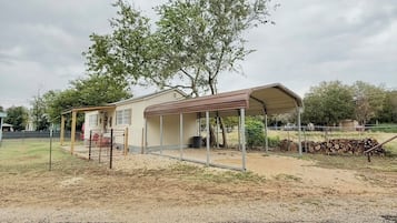 A single-story house with a covered porch and a tree in front.